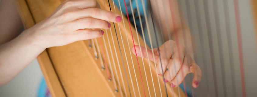 Bethan Nia playing her harp strings